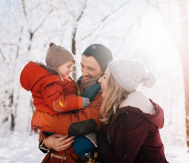 Family bundles up together outside during the winter